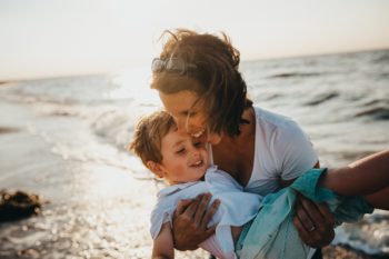 Une maman qui joue et rit avec son fils au bord de mer-Marie Duval sophrologue