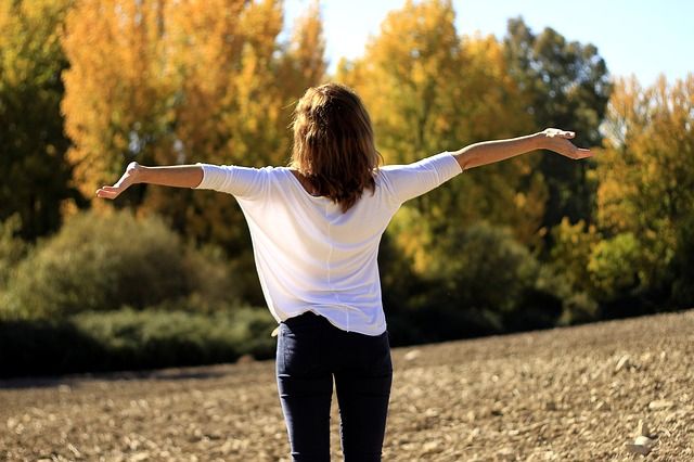 Femme en blanc qui respire les bras ouverts-Marie Duval sophrologue