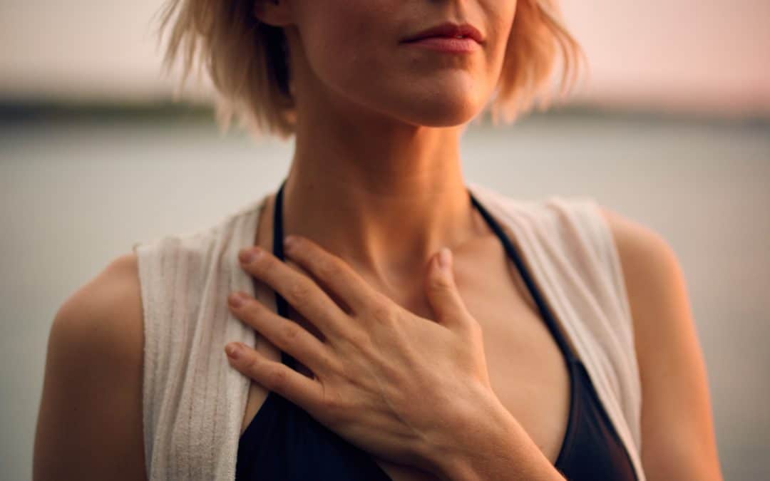 Une jeune femme respire en conscience en posant la main sur son torse-Marie Duval sophrologue