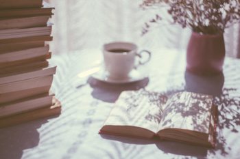 un moment de lecture devant une pile de livres -Marie Duval sophrologue