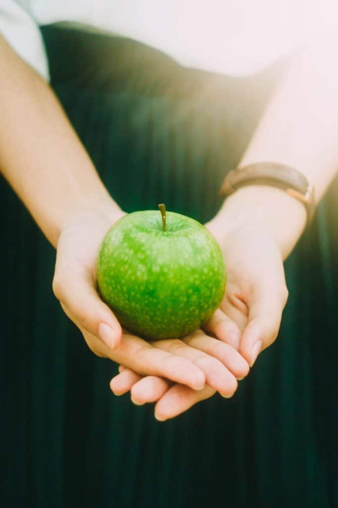 Pomme verte posée au creux des mains- Marie Duval sophrologie