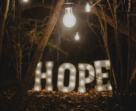 Au milieu d'arbres, le mot HOPE écrit en lumière et éclairé d'une ampoule-Marie duval sophrologue 