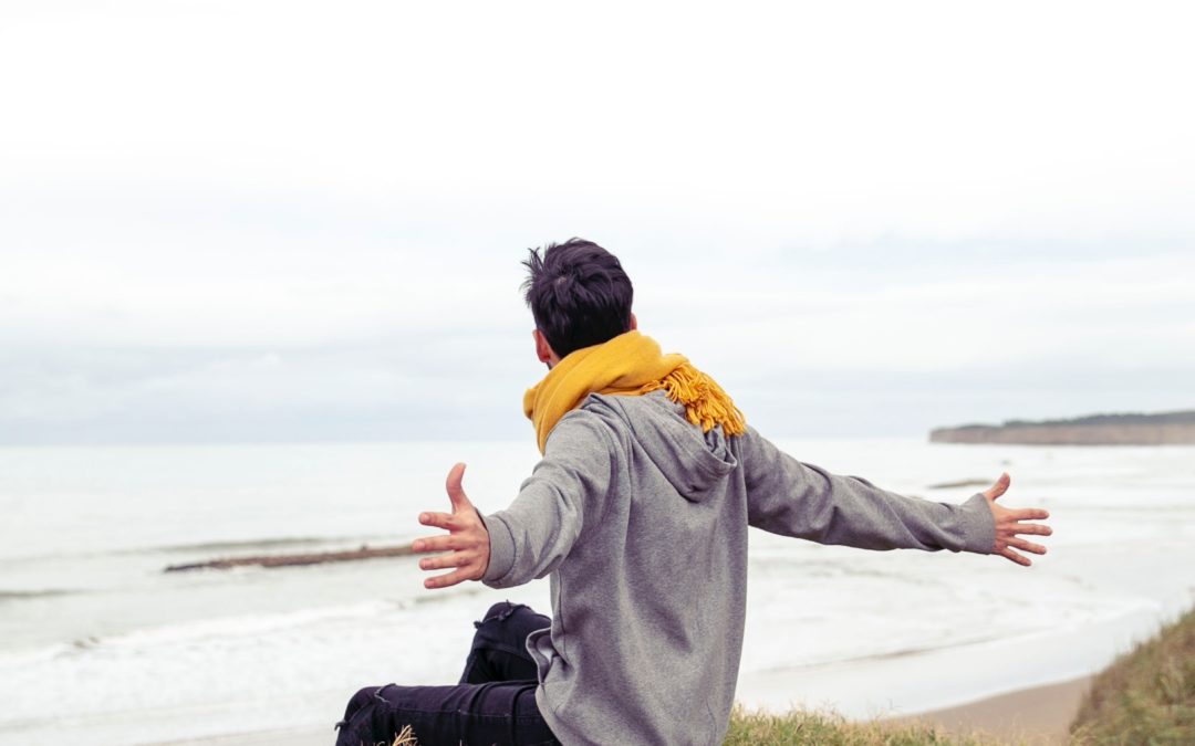 jeune homme écartant les bras face à la mer-Marie Duval sophrologue